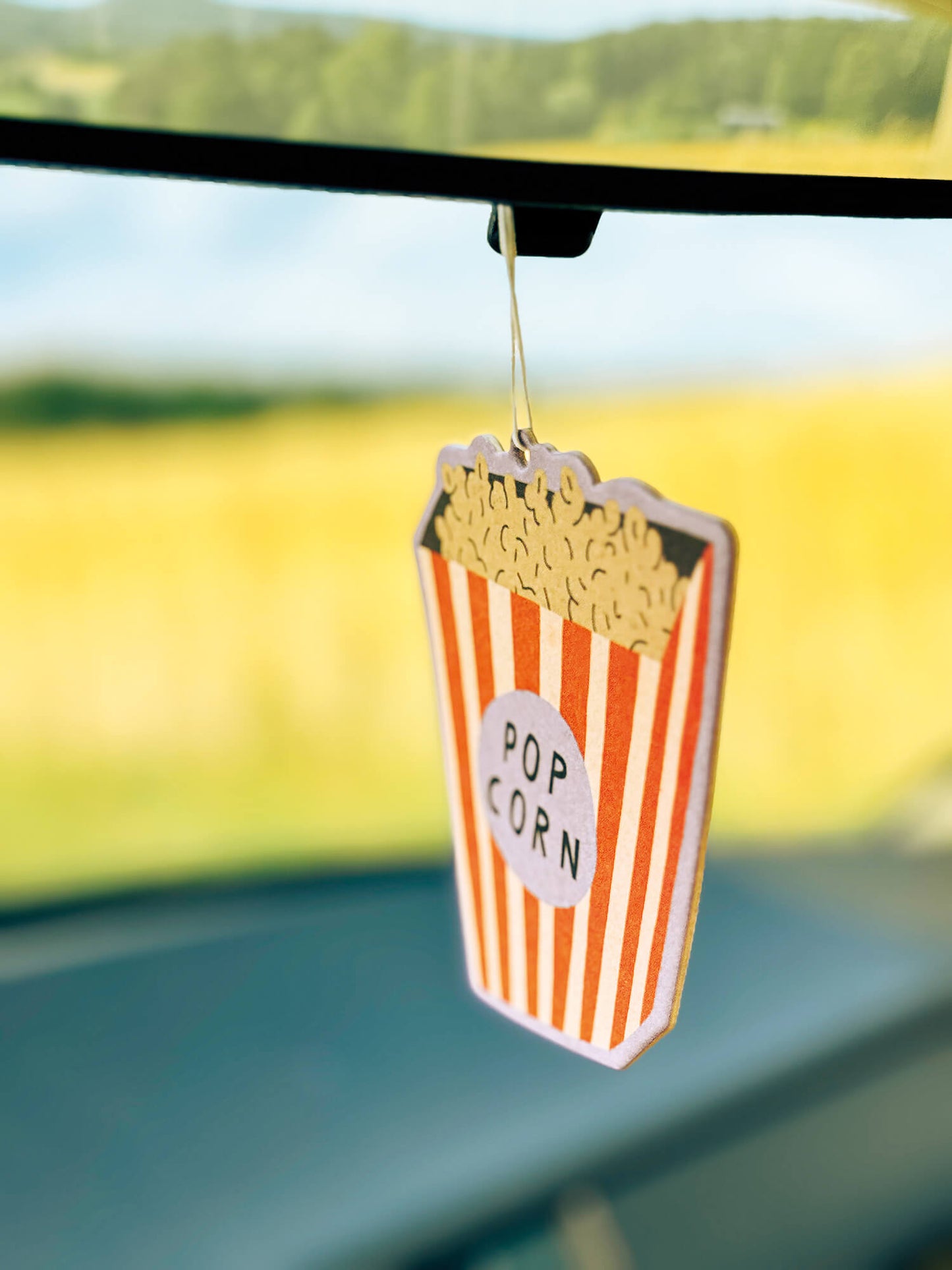 Duftanhänger in Form einer Popcorntüte am Rückspiegel im Auto