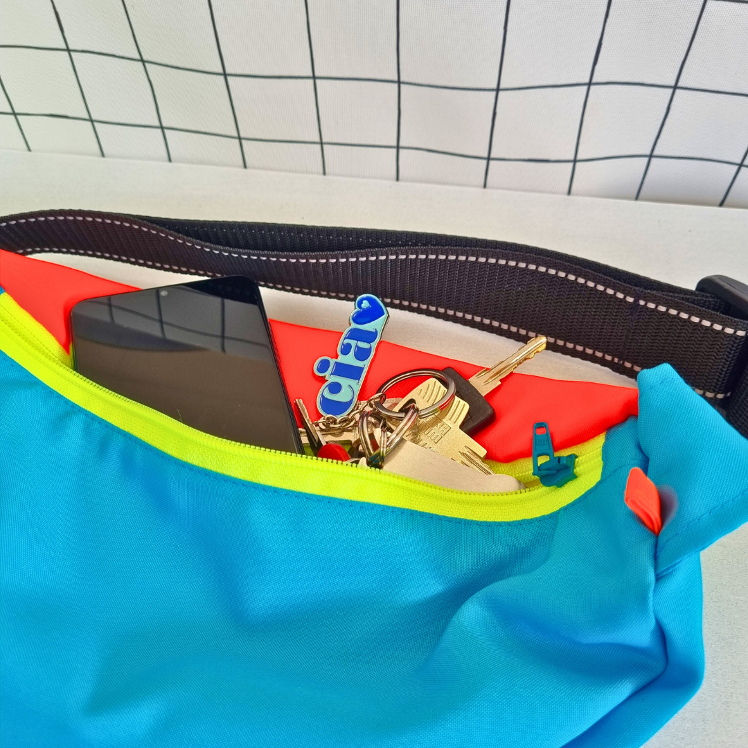 Crossbag in blau, rot und gelb mit separatem Reißverschlussfach für Handy, Schlüssel und andere Kleinigkeiten.