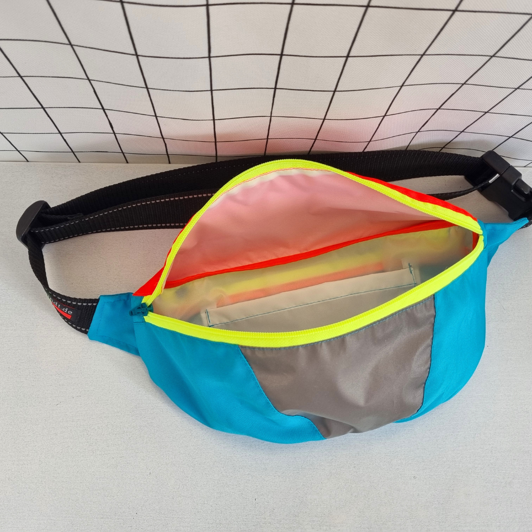 Crossbag in bunten Neon-Farben blau, gelb und rot mit weißem Innenfutter und Innentasche.