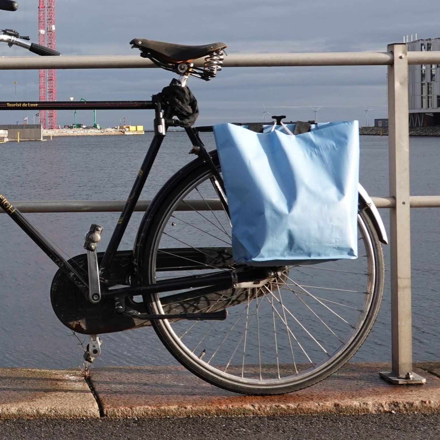 Fahrrad am Hafenkai mit hellblauer Cobag am Gepäckträger