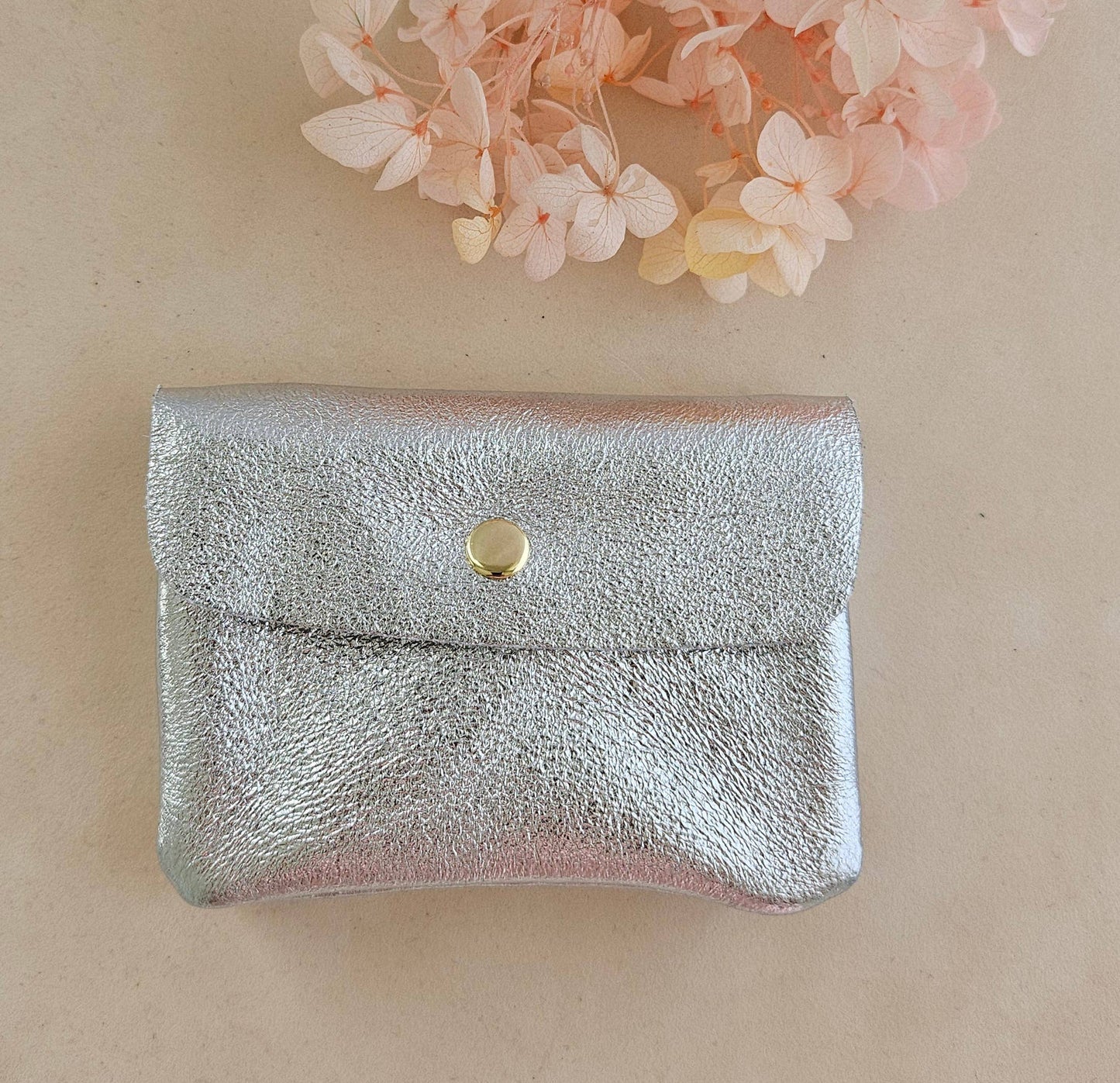 Hochwertige Geldbörse mit Druckknopf in silber metallic aus upgecyceltem leder, innen mit Reißverschlussfach.