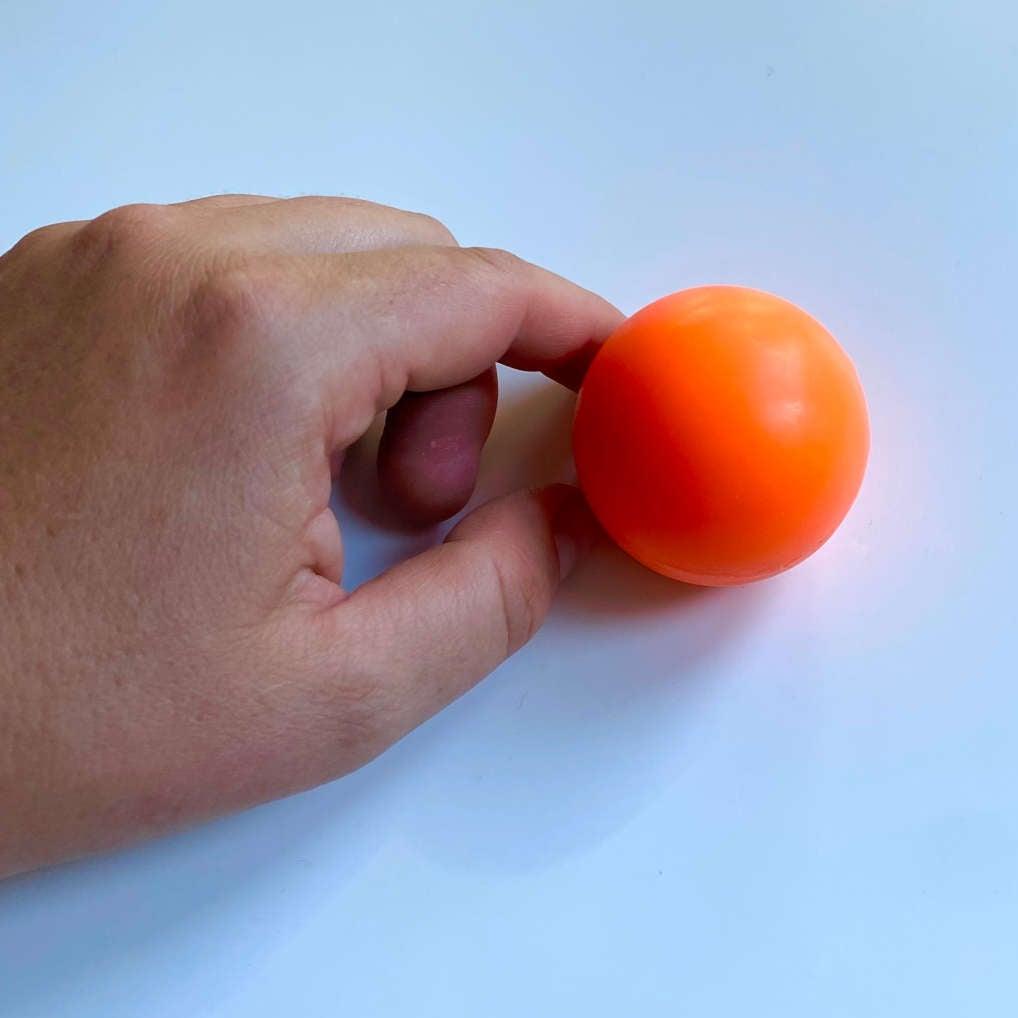 Kugelseife Mira orange neben Hand