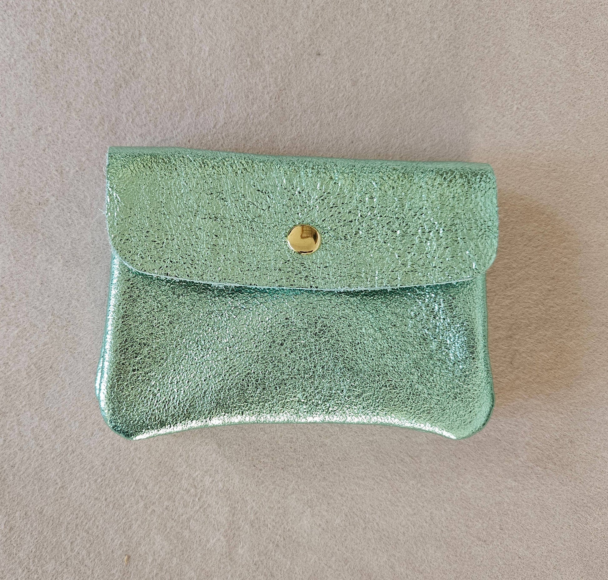 Portemonnaie aus upgecyceltem Leder mit Druckknopf und innenliegendem Reißverschlussfach in der Farbe Minze Metallic.