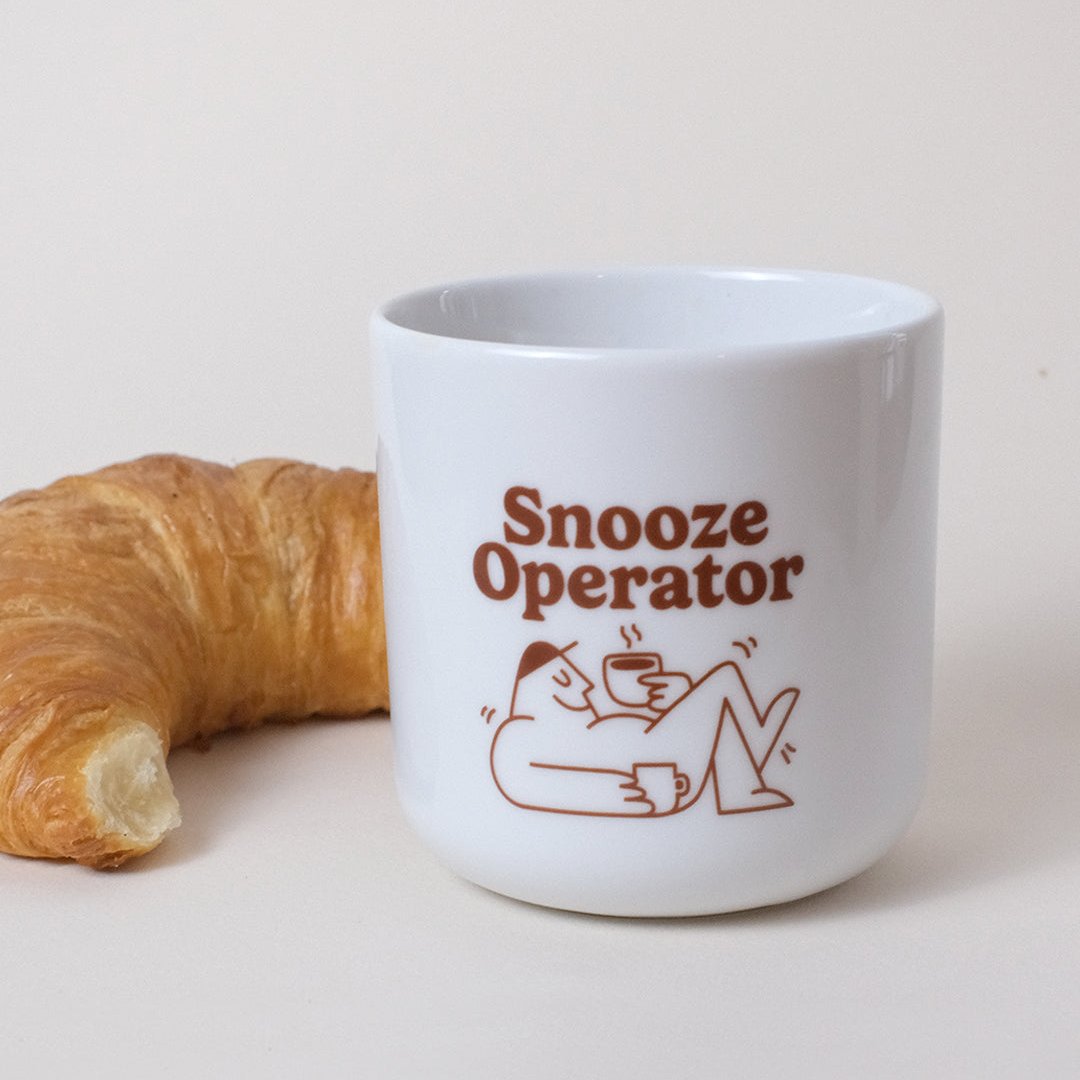 croissant mit tasse mit braunem aufdruck snooze operator 