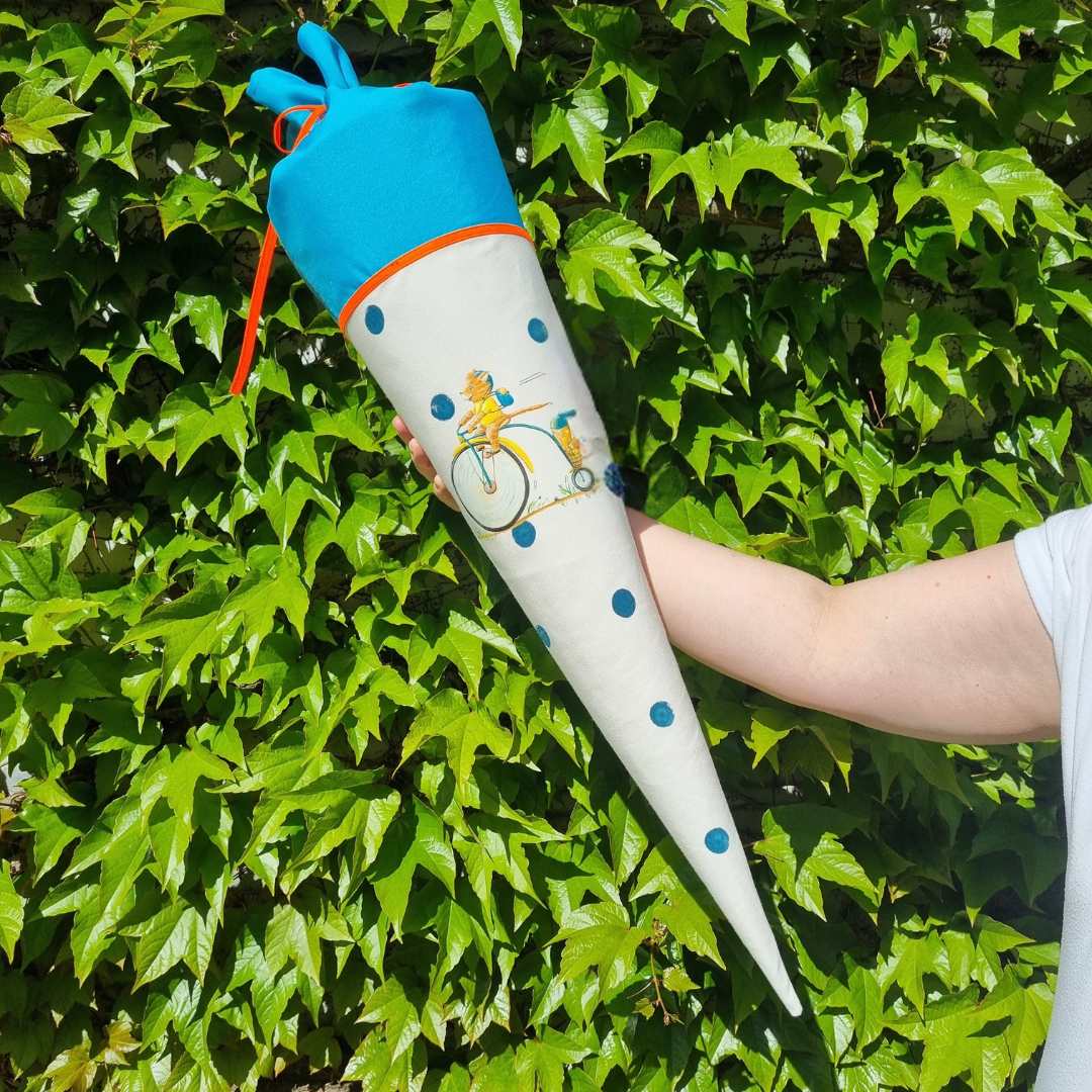 Individualisierbare, genähte Schultüte mit blauen Punkten und einer Katze auf dem Fahrrad. 70 Centimeter.